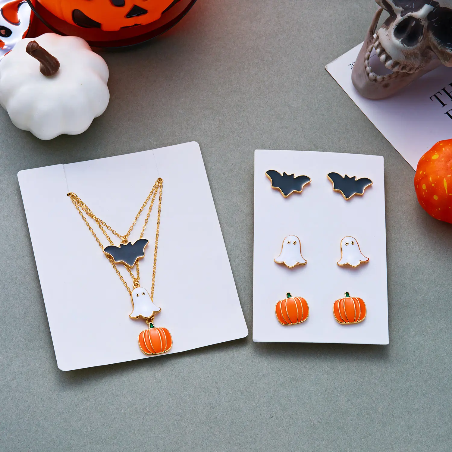 Spooky personality Halloween layered jewelry set crafted from anti-tarnish electroplated alloy. 3-tier staggered chain necklace decorated with cute enamel ghost, orange pumpkin and black bat pendants, matching coordinating ring set with identical cartoon Halloween motifs. Adjustable chain length from 41cm to 50cm, ultra-light total weight 17g for comfortable long-time party wear. Dark gothic playful vibe, ideal costume matching ornaments for Halloween parties, theme events and holiday styling for women.
