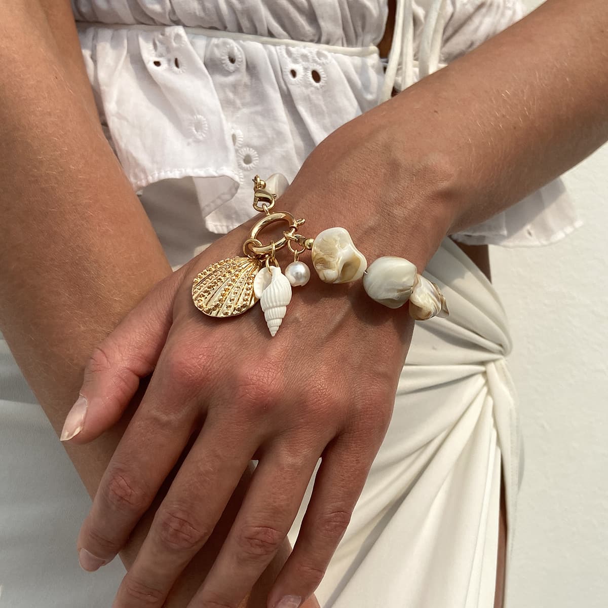 Handcrafted natural irregular shell bead collarbone necklace matching bracelet jewelry set for summer beach vacation, decorated with white shell flower, starfish, conch and textured scallop alloy pendants. Classic natural ocean element design with fresh sweet boho vacation style, adjustable length fits all neck & wrist sizes, ideal matching accessory for swimsuits, camisoles and casual travel outfits, perfect coastal holiday statement jewelry for women.