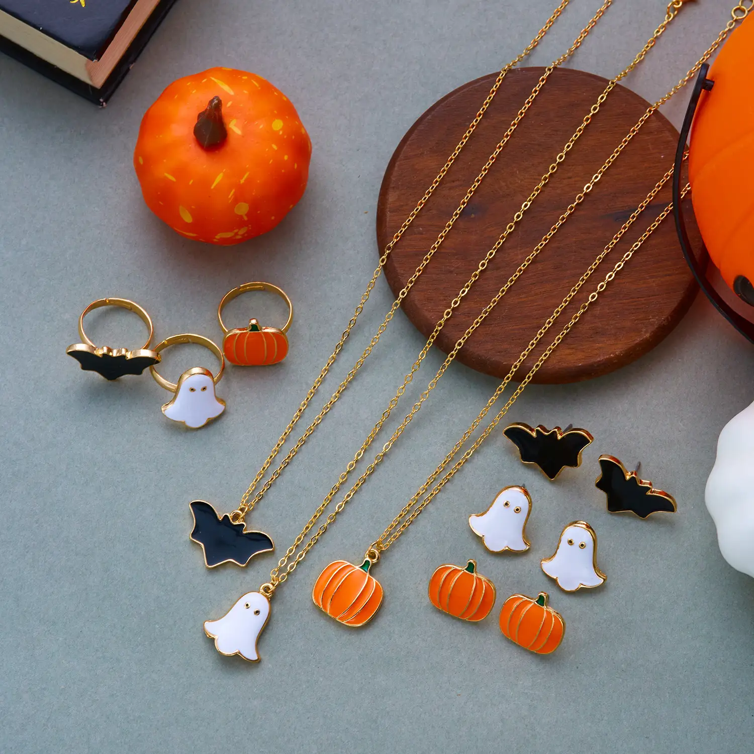 Spooky personality Halloween layered jewelry set crafted from anti-tarnish electroplated alloy. 3-tier staggered chain necklace decorated with cute enamel ghost, orange pumpkin and black bat pendants, matching coordinating ring set with identical cartoon Halloween motifs. Adjustable chain length from 41cm to 50cm, ultra-light total weight 17g for comfortable long-time party wear. Dark gothic playful vibe, ideal costume matching ornaments for Halloween parties, theme events and holiday styling for women.