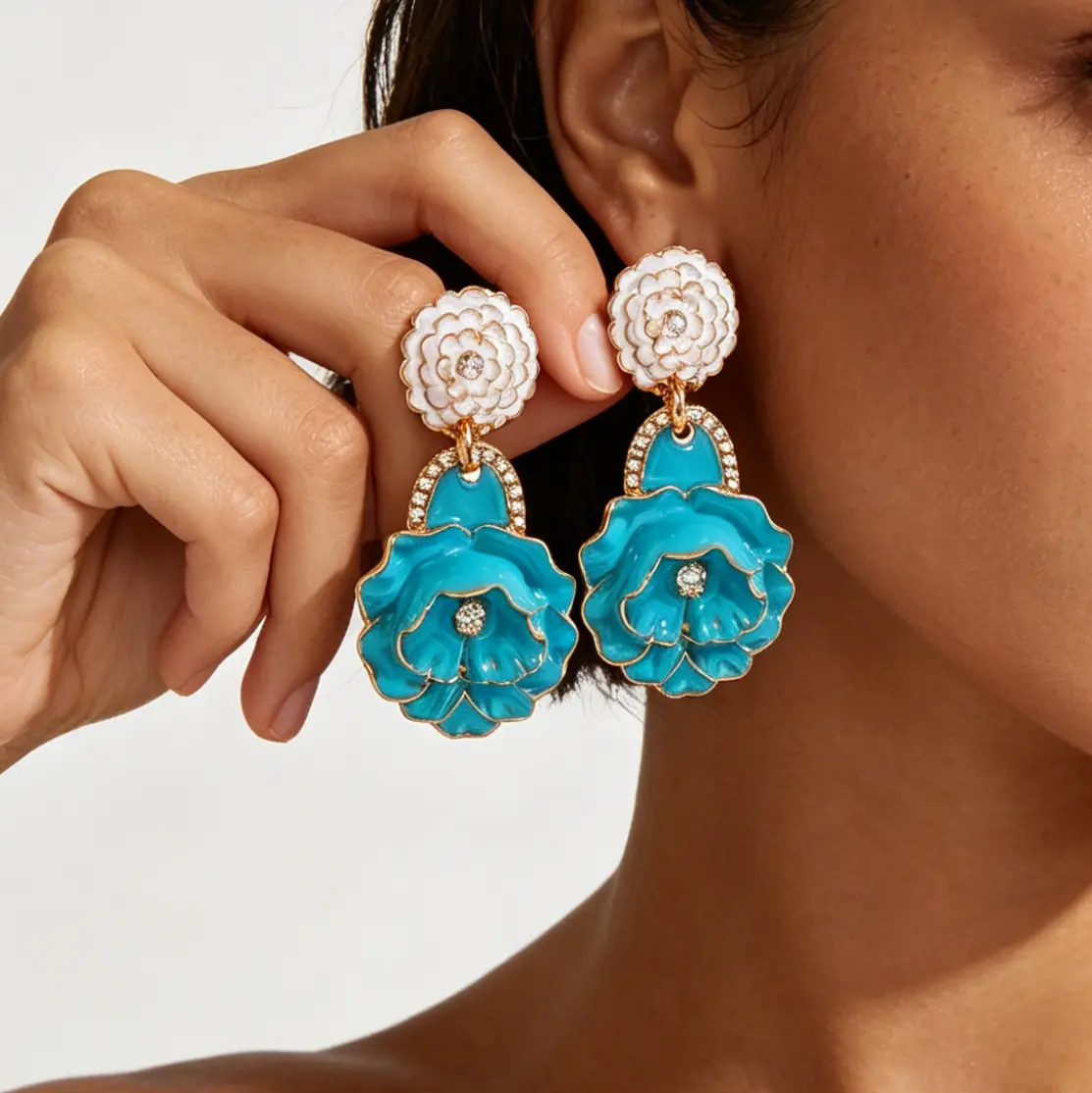 Material Performance: Solid zinc alloy flower frame, glossy uniform drip enamel coating, clear sparkling rhinestones, sturdy bend-resistant iron ear pins Structure Design: Double-layer vertical drop structure, small top flower + rhinestone link + large three-dimensional rose pendant Enamel Craft: Smooth full-color glaze filling, distinct petal contour golden metal edging, long-lasting bright color without fading Silhouette Advantage: Oversized vertical layered floral shape, visually lengthen neck lines and brighten facial makeup Wearing Comfort: Well-balanced lightweight integrated molding, no heavy dragging pressure on earlobes for all-day wear Color Selection: Five high-saturation dopamine bright tones to match all summer holiday and casual wardrobes Craftsmanship: Secure welded connecting links, firmly set rhinestones, seamless polished metal edges without burrs Wearing Structure: Dangle drop stud earrings, simple to put on and take off for daily & party styling Styling Positioning: Luxury ZA-style dopamine multi-layer enamel flower statement earrings, multi-scene beach commute party fashion ear jewelry Applicable Matching: Linen resort dresses, bikini cover-ups, silk camisoles, vintage blouses and romantic date outfits