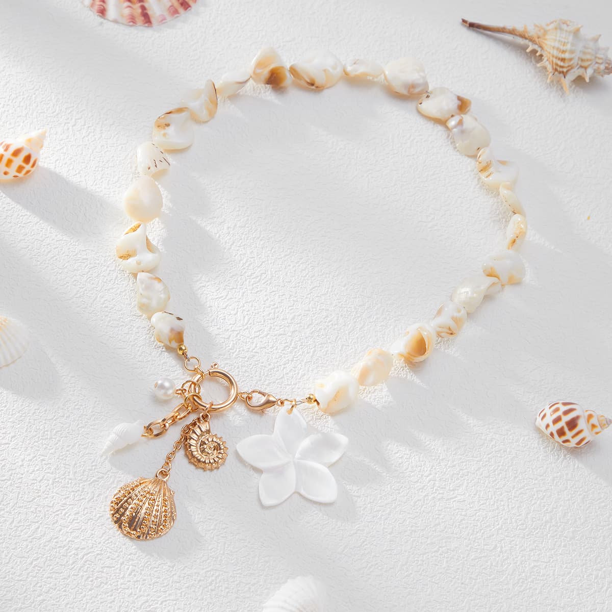 Handcrafted natural irregular shell bead collarbone necklace matching bracelet jewelry set for summer beach vacation, decorated with white shell flower, starfish, conch and textured scallop alloy pendants. Classic natural ocean element design with fresh sweet boho vacation style, adjustable length fits all neck & wrist sizes, ideal matching accessory for swimsuits, camisoles and casual travel outfits, perfect coastal holiday statement jewelry for women.